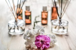 An essential oil kit being used on a wood table next to picked flowers